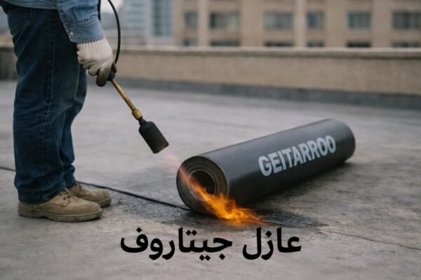 عامل كويتي يقوم بتثبيت لفائف العزل البيتومينية السوداء على سطح مبنى